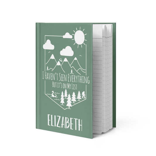 Personalized Adventure Travel Hardcover Journal with mountain scene with loch ness, alien spaceship & bigfoot with your name on the bottom. 