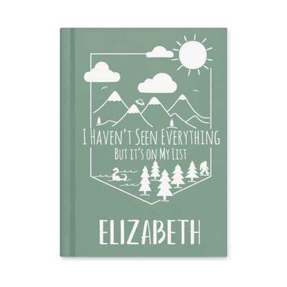 Personalized Adventure Travel Hardcover Journal with mountain scene with loch ness, alien spaceship & bigfoot with your name on the bottom. 