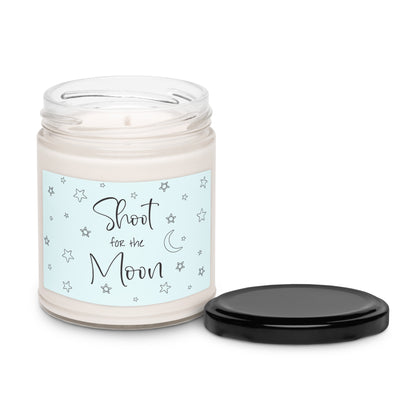 White apple harvest scented soy candle in a clear glass jar with a light blue background, stars scattered and a moon and states 'Shoot for the Moon'.