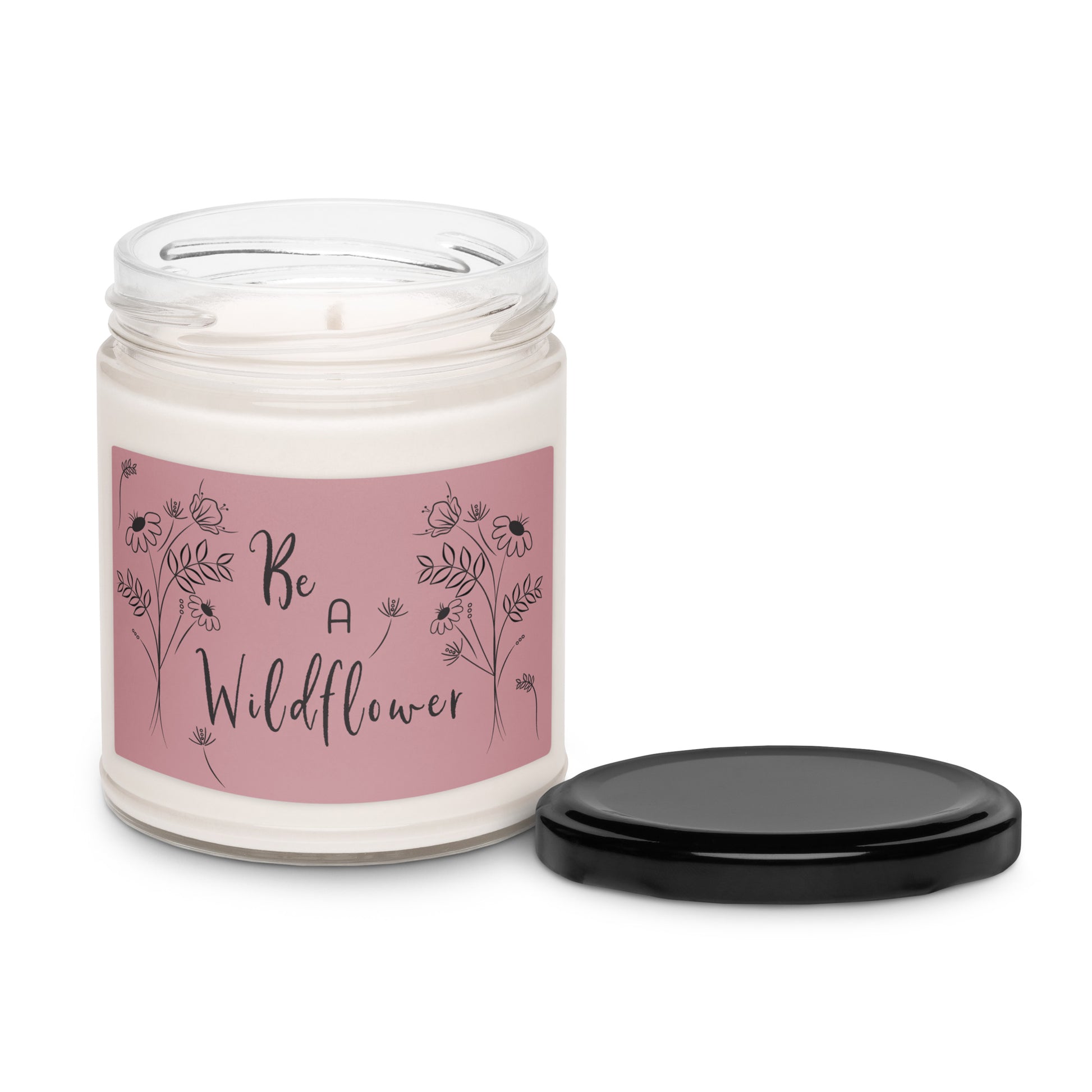 White apple harvest scented soy candle in a clear glass jar with a pink label and wildflowers that states 'Be a Wildflower'.