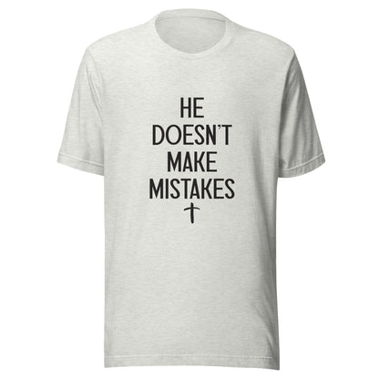Gray Unisex short sleeve tee says He Doesn't Make Mistakes with a small cross at the bottom. 