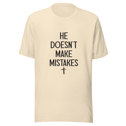 Heather natural Unisex short sleeve tee says He Doesn't Make Mistakes with a small cross at the bottom. 