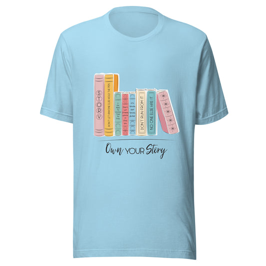 Ocean blue unisex short sleeve t-shirt that says 'Own Your Story' with multi-colored books with sassy titles such as Don't run from it and no one else has it.