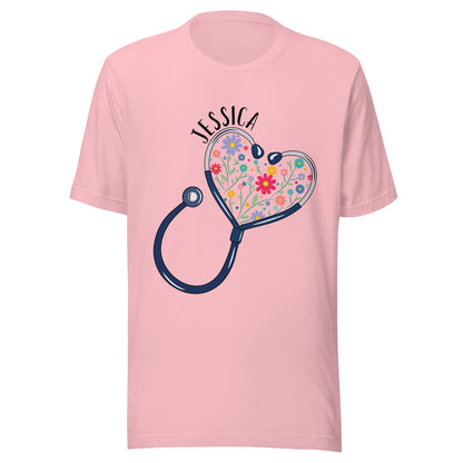 Unisex pink short sleeve t-shirt with a stethoscope in the shape of a heart with multi-colored flowers inside and personalized with a name hugging the top of the heart shape. 