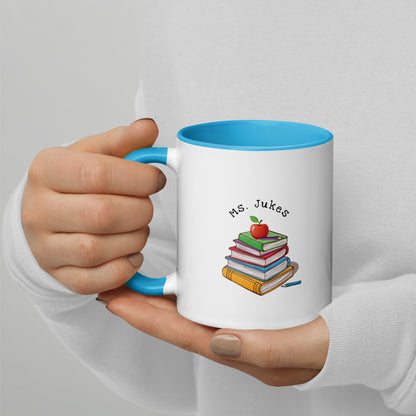 Personalized with Teacher name that says Turning Lessons Into Adventure printed on both sides on white Ceramic Mug with blue color handle and inside of mug.