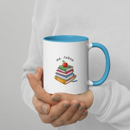 Personalized with Teacher name that says Turning Lessons Into Adventure printed on both sides on white Ceramic Mug with blue color handle and inside of mug.