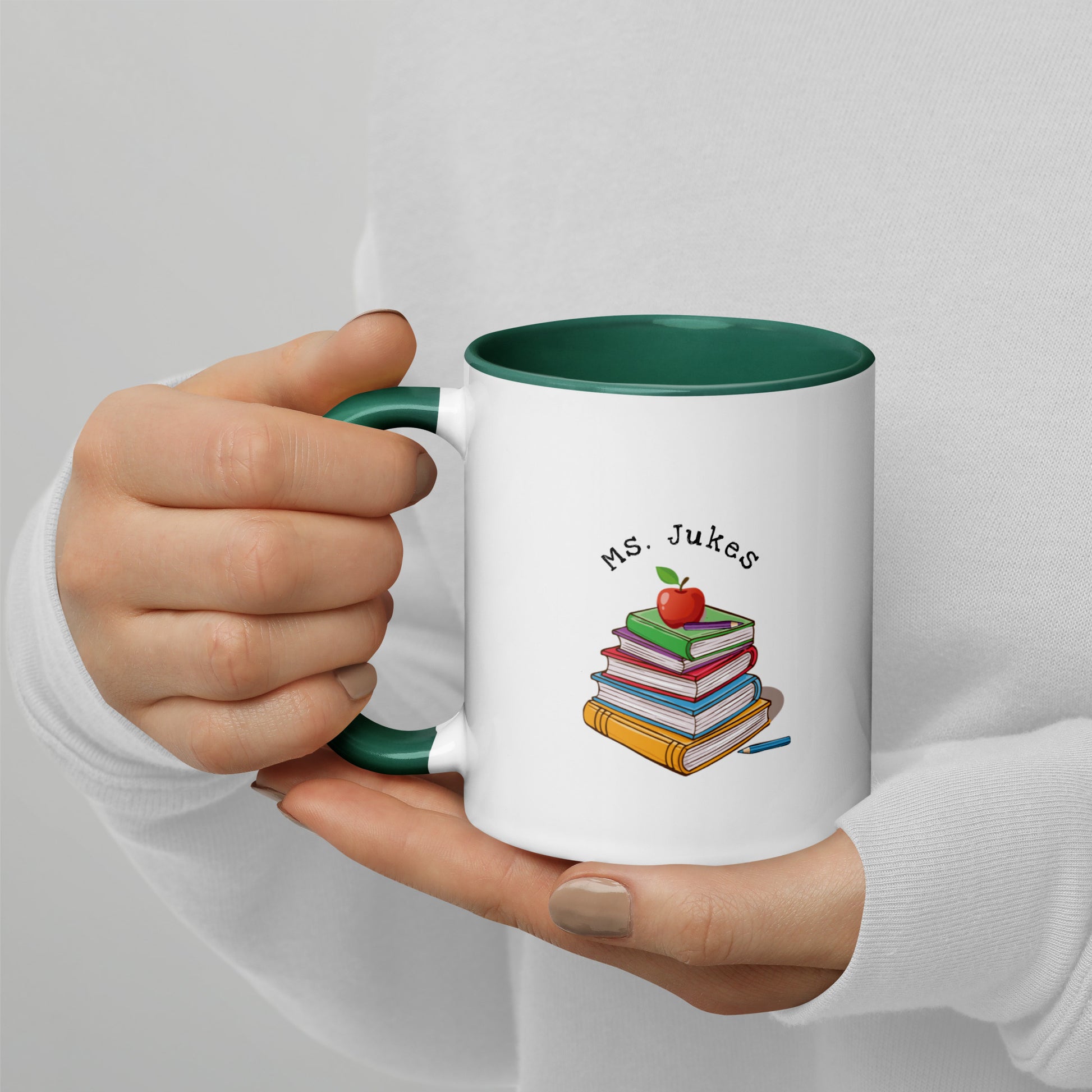 Personalized with Teacher name that says Turning Lessons Into Adventure printed on both sides on white Ceramic Mug with green color handle and inside of mug.