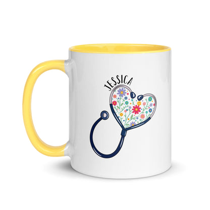 11 oz white ceramic mug with yellow handle with with a stethoscope in the shape of a heart with multi-colored flowers inside and personalized with a name hugging the top of the heart shape. 